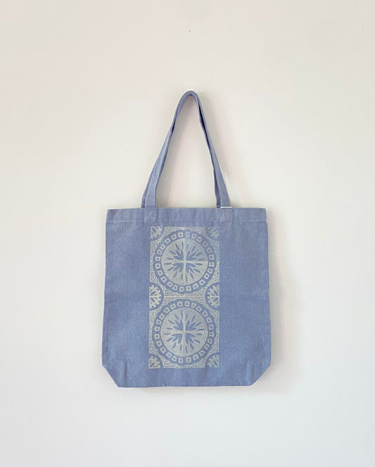 Blue tote bag with block printed vintage tile design in white.